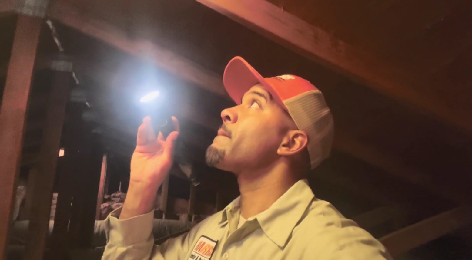 A man in an orange hat looking up at the ceiling.